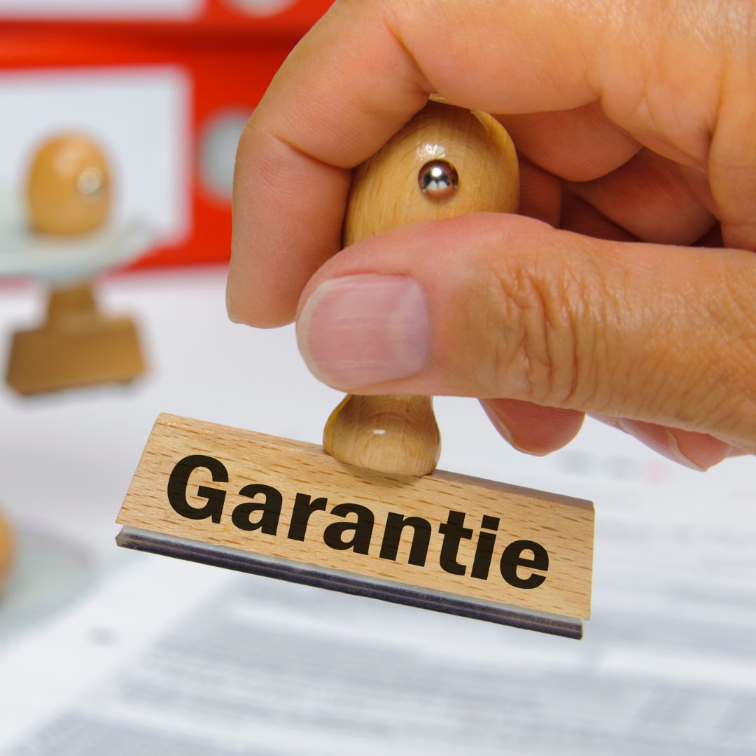 Hand hält einen Stempel mit der Aufschrift "Garantie"